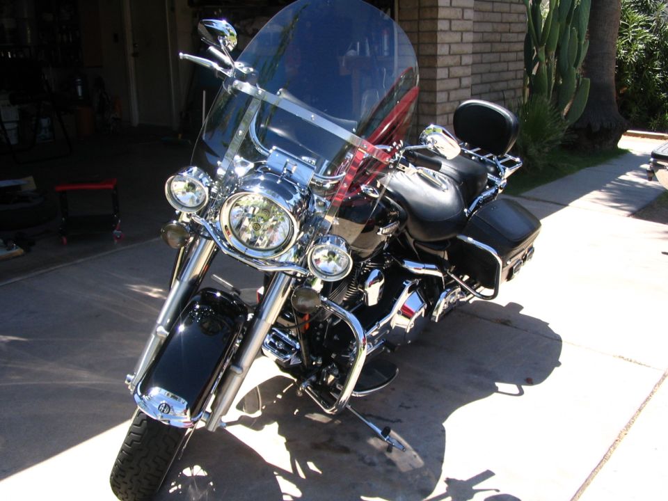 Black Harley-Davidson touring bagger with windshield and saddlebags on a driveway
