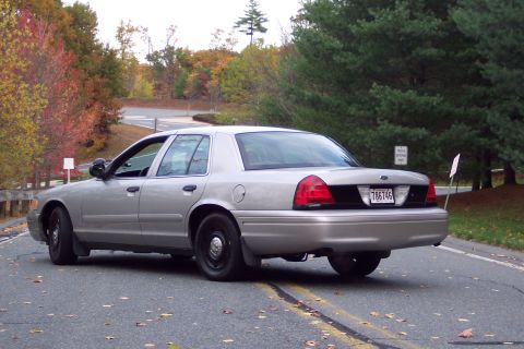 2001 Ford Crown Victoria - A silver 2001 Ford Crown Victoria sedan is seen from the rear 3/4 angle on a road during autumn.
