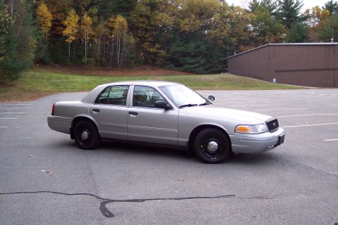 2001 Ford Crown Victoria - Silver 2001 Ford Crown Victoria sedan parked outdoors in a lot during autumn.