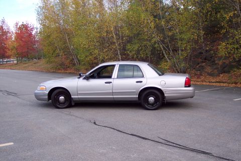 2001 Ford Crown Victoria - A silver 2001 Ford Crown Victoria sedan is parked on asphalt during autumn.