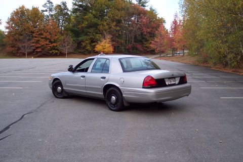 2001 Ford Crown Victoria - Silver 2001 Ford Crown Victoria sedan parked in an empty lot during autumn.