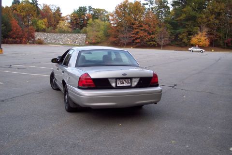 2001 Ford Crown Victoria - Rear view of a silver 2001 Ford Crown Victoria sedan in a parking lot during autumn.