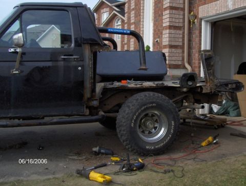 1986 Ford Bronco - This black pickup truck chassis, seen from the side, appears to be undergoing modification or repair.
