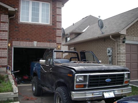 1986 Ford Bronco - This black convertible SUV features a distinctive grille and Ford badging, suggesting an early 1980s model.