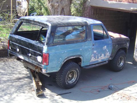 1986 Ford Bronco - This 1986 Ford Bronco is undergoing bodywork and repairs, with primer visible on the front fender.