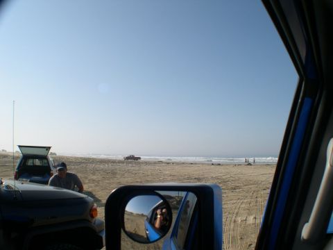 2007 Toyota FJ Cruiser - Vehicles are parked on the sand with the ocean and waves in the background under a clear blue sky.