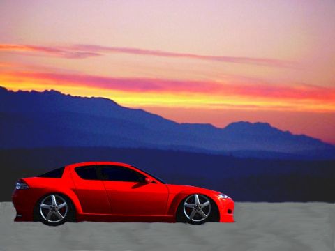 1996 Ford Taurus - A red sports car is parked with a mountain range and a vibrant sunset in the background.