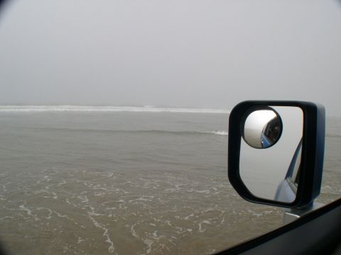 2007 Toyota FJ Cruiser - View from a vehicle's side mirror shows the ocean and sky on a foggy day.