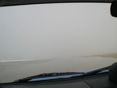 2007 Toyota FJ Cruiser - Driving along the coast on a foggy day, with the ocean waves visible through the windshield.