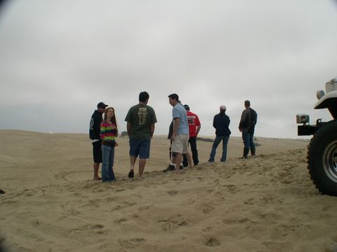 2007 Toyota FJ Cruiser - A white 2007 Toyota FJ Cruiser is partially visible on a sandy dune with a group of people standing nearby.