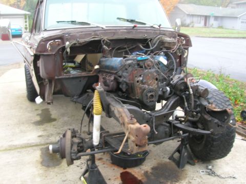 1978 Ford F-250 - The front end of a Ford F-Series truck is shown with the engine removed and the vehicle supported by jack stands.