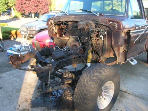 1978 Ford F-250 - The engine bay of a brown 1970s Ford F-250 truck is exposed, with the engine and transmission removed.