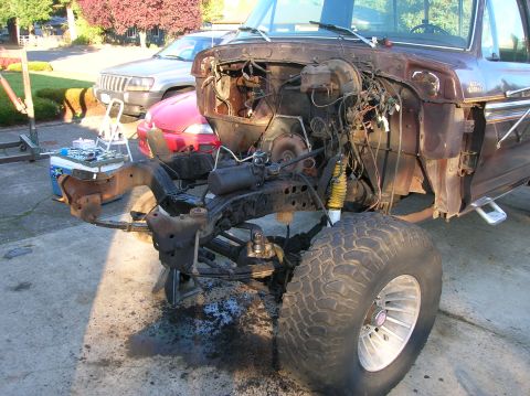 1978 Ford F-250 - The engine bay of a 1978 Ford F-250 pickup truck is shown with the engine removed, revealing the chassis and suspension components.