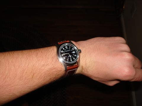 1994 Ford Bronco - A close-up shot shows a Hamilton watch with a black face and brown leather strap on a person's wrist.
