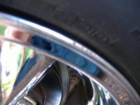 1999 Ford Mustang - Detail of a chrome wheel and tire, with some text visible on the tire sidewall.