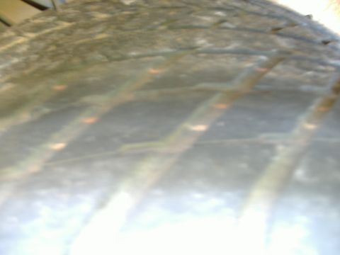 1999 Ford Mustang - Close-up of tire tread detail, showing wear patterns and orange markings.