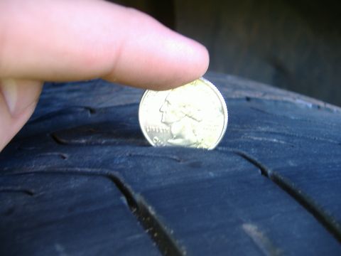 1999 Ford Mustang - Checking tire tread depth with a quarter coin.