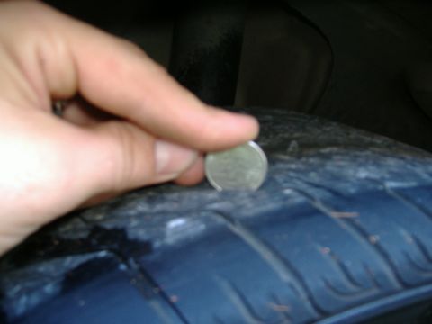 1999 Ford Mustang - Checking tire tread depth with a coin.