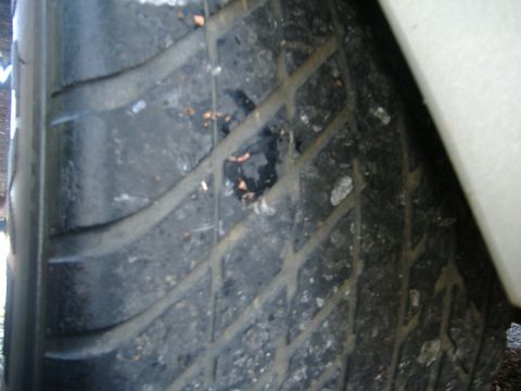 1999 Ford Mustang - Tire tread shows damage and embedded debris.