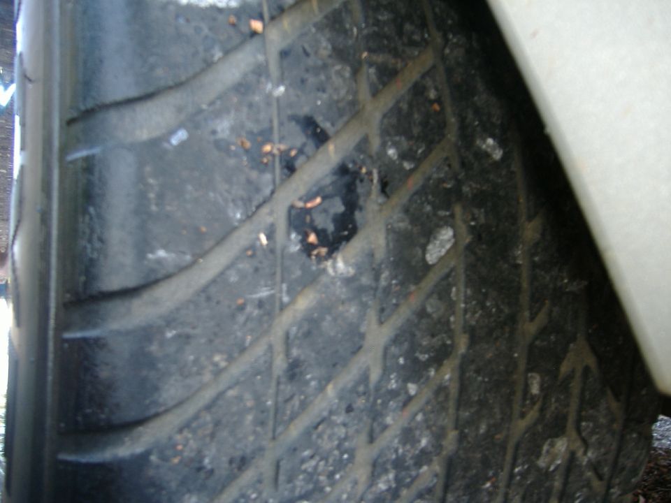 Close-up of a damaged tire tread with debris embedded