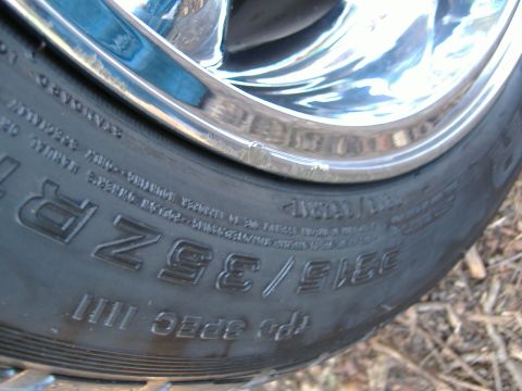 1999 Ford Mustang - A close-up view of a tire and chrome rim, showing tire size information.