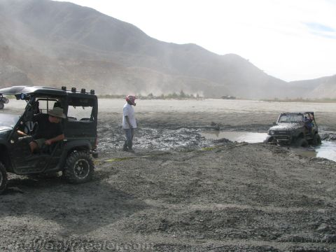 1987 Suzuki Samurai - A Suzuki Samurai navigates a muddy terrain, with another off-road vehicle visible in the background.
