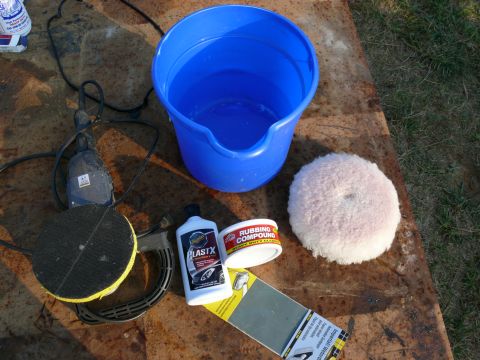 1988 Ford Bronco - Car detailing supplies are laid out on a rusty surface, ready for use.