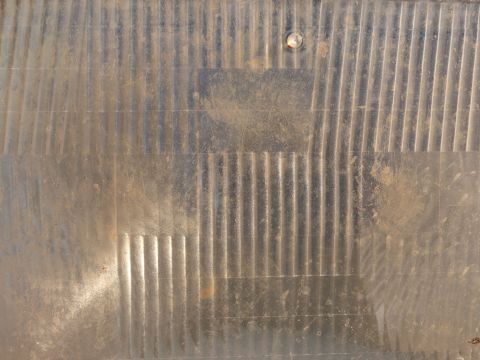 1988 Ford Bronco - Close-up of a vehicle's headlight lens, showing its textured surface and a mounting stud.