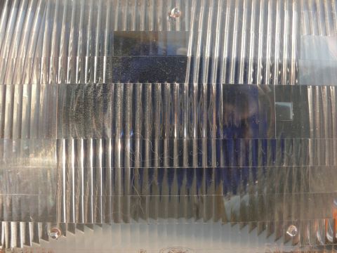 1988 Ford Bronco - Close-up of a vehicle headlight lens, showing its textured surface and the Supermotors.net logo.