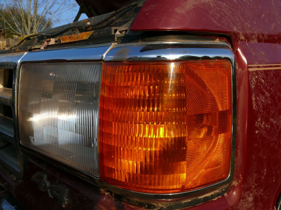 Red 1988 Ford Bronco front headlight and amber turn signal assembly