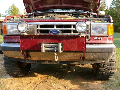 1988 Ford Bronco - Front view of a Ford Bronco with a winch mounted on the bumper. 4x4 badging is present.