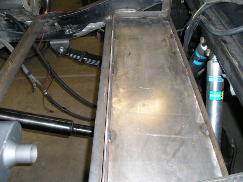 1986 Toyota Hilux - Custom metal storage box installed on a vehicle's undercarriage, showing suspension components.