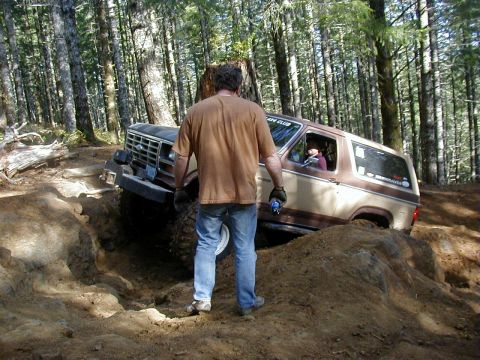 1994 Ford Explorer - Ford Bronco tackling a challenging off-road course in a wooded area.