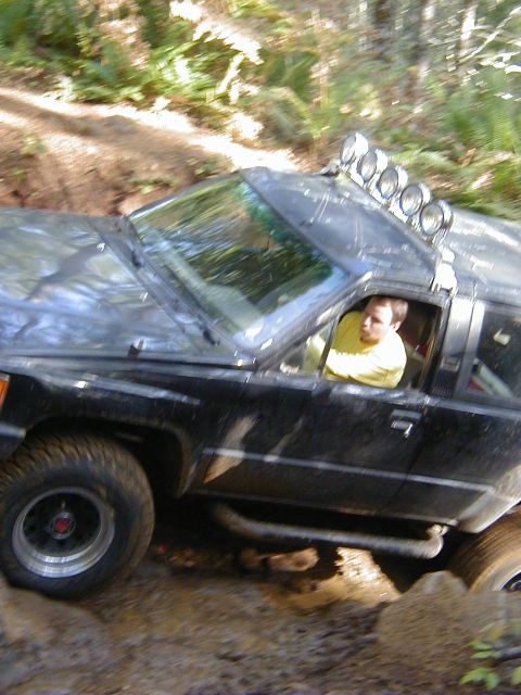 1994 Ford Explorer - A black SUV with auxiliary lights on its roof navigates a challenging off-road course.