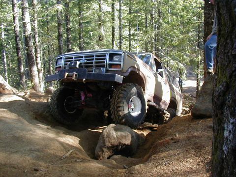 1994 Ford Explorer - This off-road SUV navigates a challenging rocky trail through a wooded area.