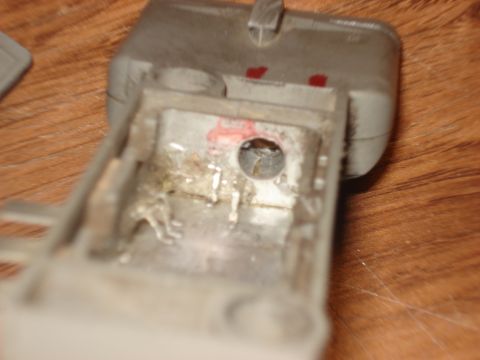 1986 Ford Bronco - Detail of a gray plastic car interior component, showing metal and red markings.