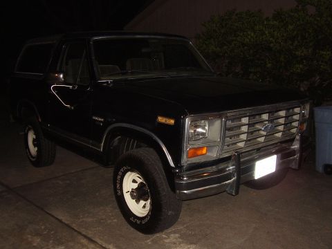 1986 Ford Bronco - This black Ford Bronco, likely from the early 1980s, is shown parked at night.
