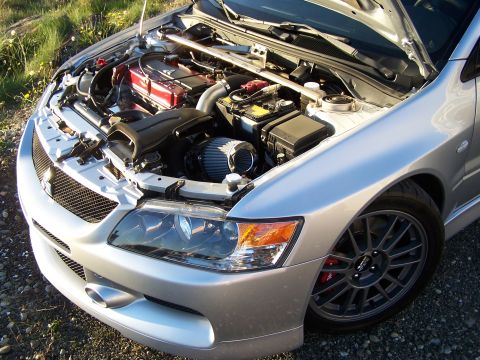 1995 Ford Probe - The engine bay of a silver Mitsubishi Lancer Evolution is visible with the hood raised.