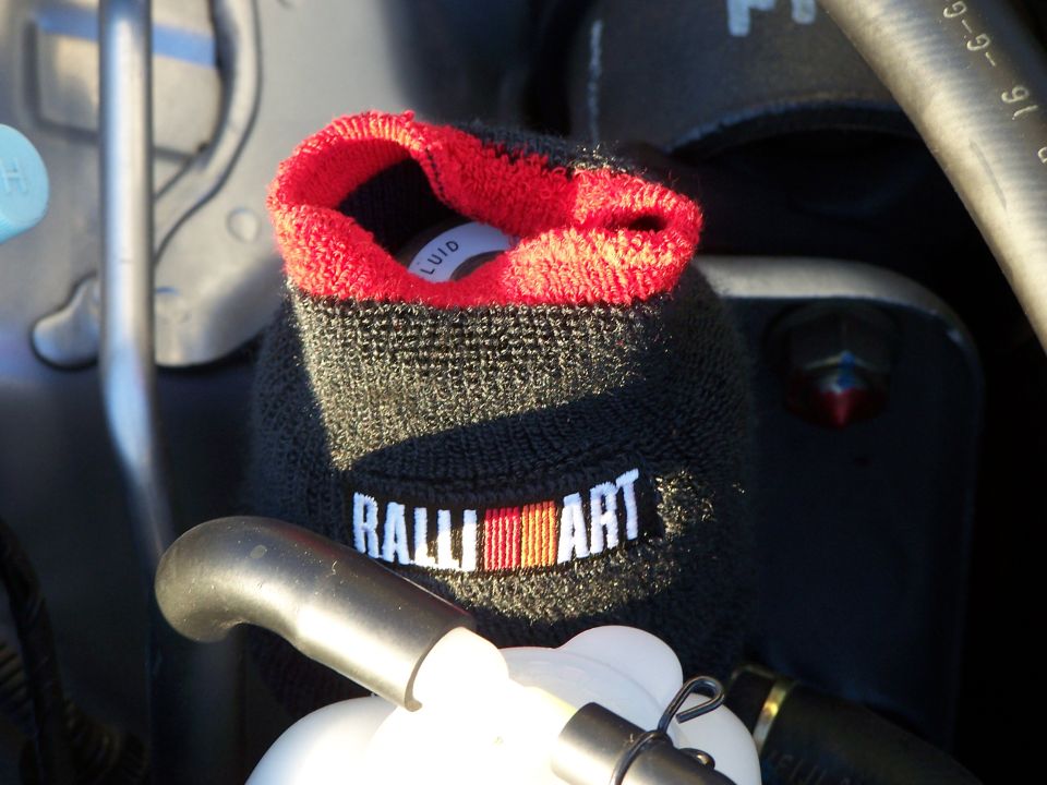 Black Ralliart cover with red trim on an engine component, showing the word Ralliart