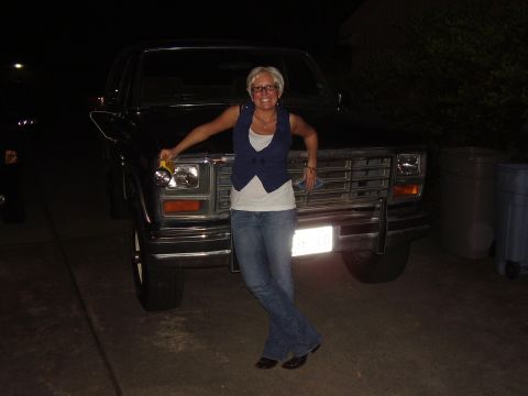 1986 Ford Bronco - A woman poses in front of a 1986 Ford Bronco at night.