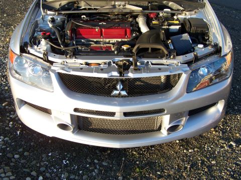 1995 Ford Probe - The front of a silver Mitsubishi Lancer Evolution IX is shown with its hood open, revealing the engine bay.