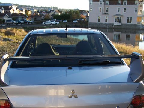 1995 Ford Probe - Rear view of a silver Mitsubishi Lancer Evolution with a prominent spoiler and roof spikes.
