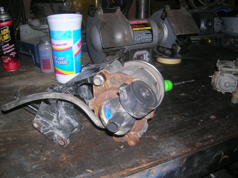 1985 Ford Bronco - A close-up view of an automotive part resting on a wooden workbench.