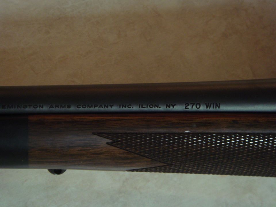 Close-up of Remington rifle barrel stamped 270 WIN above a checkered walnut forend