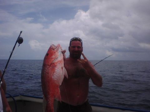 1995 Ford Bronco - Man proudly displays a large red snapper caught while fishing from a boat.