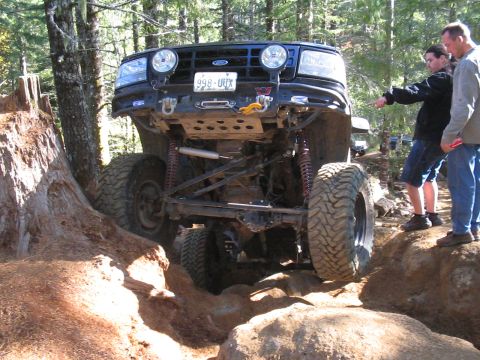 1989 Ford Bronco - A modified 1992 Ford Bronco navigates a challenging off-road trail with onlookers observing.