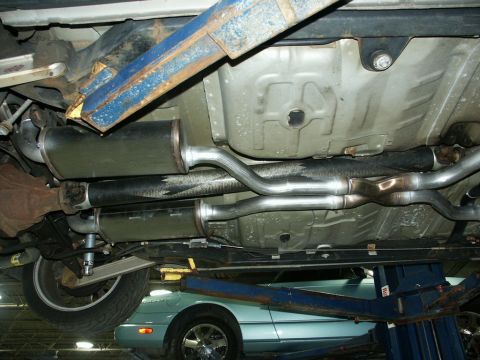 2001 Mercury Grand Marquis - The underside of a vehicle is shown, a dual exhaust system with two mufflers and an X-pipe configuration.