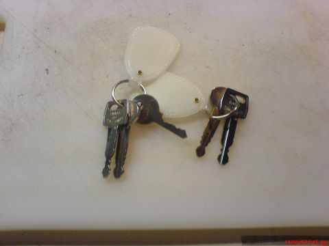 1986 Ford Bronco - A collection of keys and blank fobs are laid out on a white surface, with a SuperMotors.net watermark visible at the bottom.