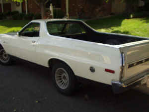1973 Ford Ranchero - White Ford Ranchero pickup truck seen from the rear quarter angle. Watermark present.