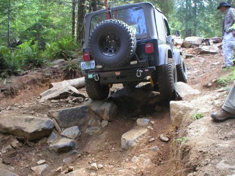 2005 Jeep Wrangler - Jeep Wrangler navigating a difficult rocky obstacle on an off-road trail.
